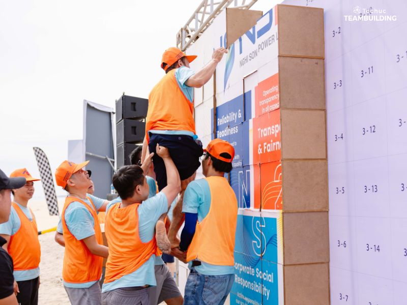 Các thành viên hỗ trợ đồng đội để xếp và xây nên tòa tháp cao nhất